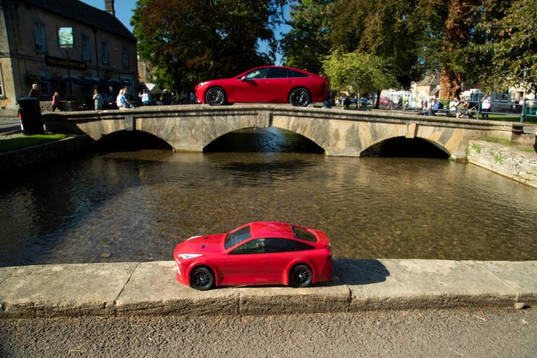 Both little and large Mirai cars, crossing bridges in Bourton-on-the-Water