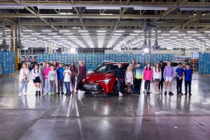 A group of children of Toyota Burnaston factory workers compare the Carina E from 1992 and the Corolla GS hatchback hybrid in new film. To the left of the Corolla is children's TV presenter, Grace Webb. www.rkpphotography.co.uk.